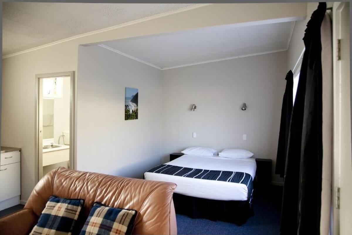A hotel room with a bed, a desk, and a chair.