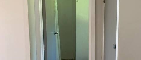 Un pasillo estrecho que conduce a un baño con inodoro y zona de ducha.