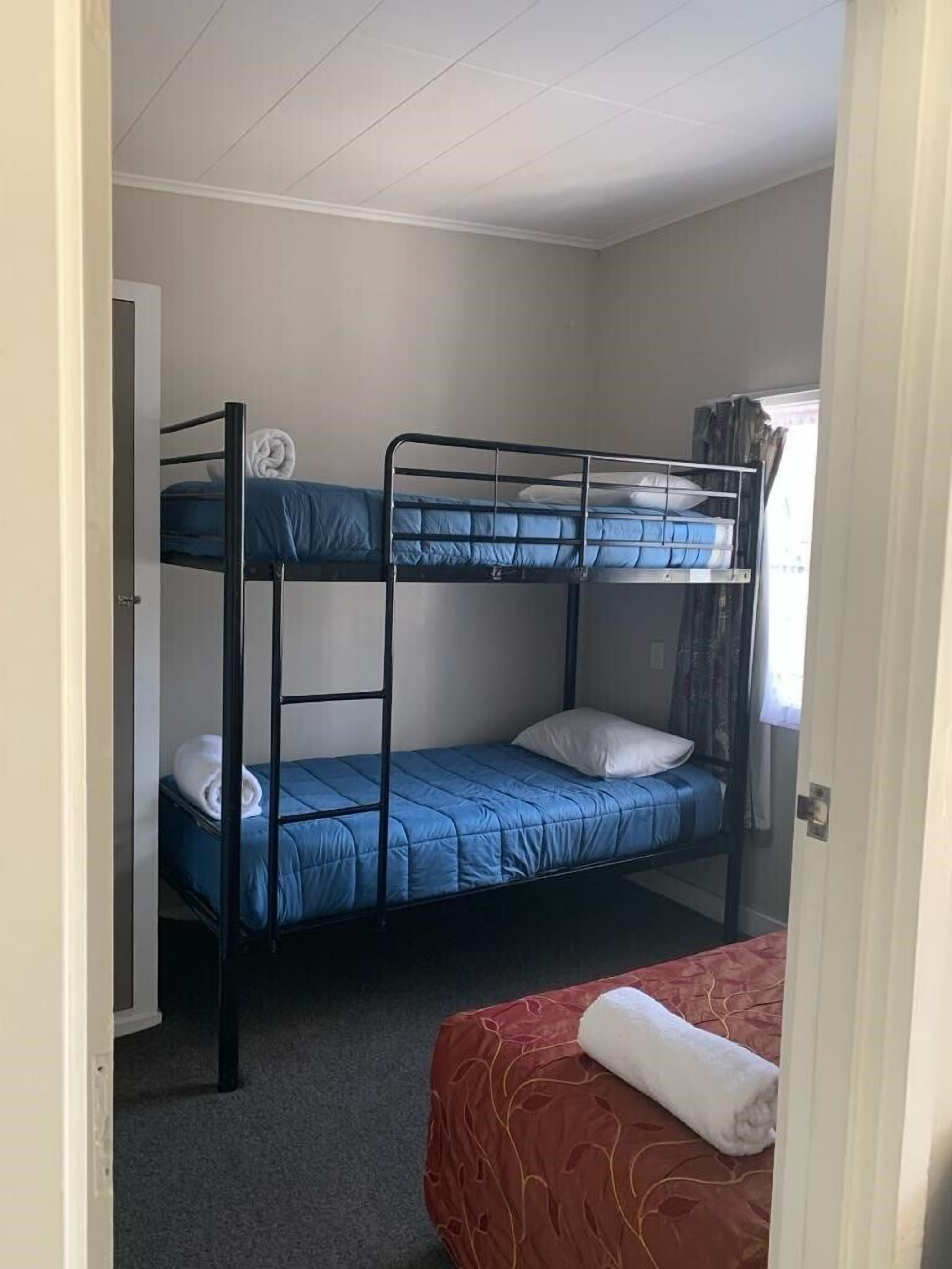 A bunk bed room with a red bed at the bottom and a blue bed on top.