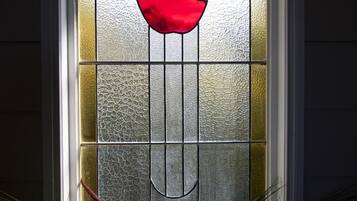 A stained glass window with a red apple design.