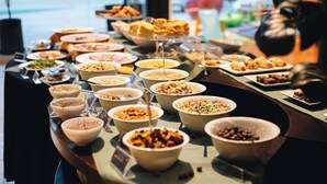 A buffet with various food items and a person in the background. - Mod Hotels Mendoza (Mendoza)