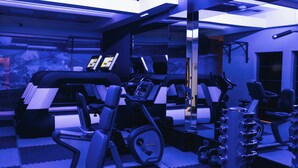 A gym with exercise equipment, a mirrored wall, and a ceiling with recessed lighting. - Mod Hotels Mendoza (Mendoza)
