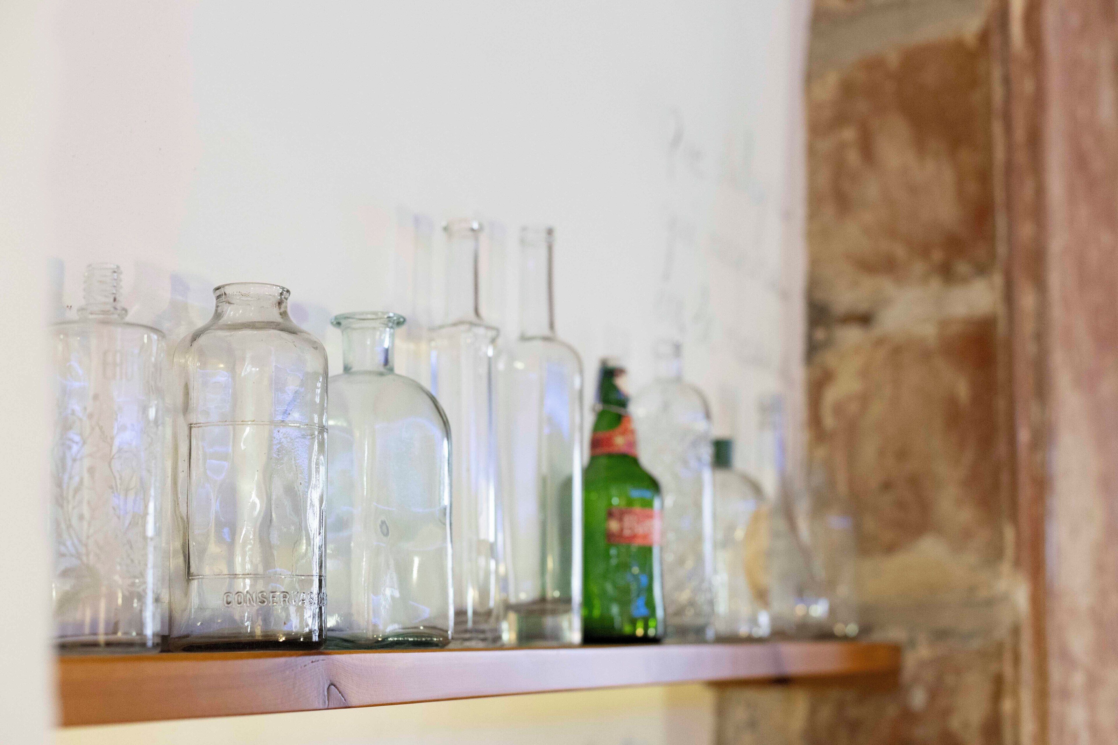 A shelf with various glass bottles and containers.