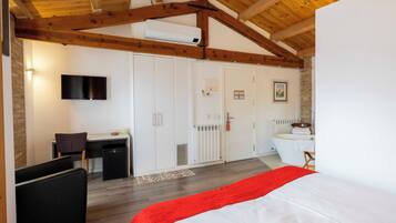 Une chambre à coucher avec un lit, un bureau et un téléviseur.