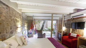 Une chambre à coucher avec un lit, un canapé rouge et un téléviseur.