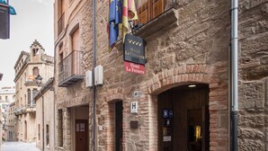Un bâtiment en pierre portant une enseigne indiquant « Hôtel La Freixerera », avec une architecture européenne traditionnelle, une entrée bien visible et un petit balcon.