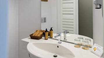 Une salle de bain moderne avec un lavabo blanc, un miroir et un porte-serviettes.