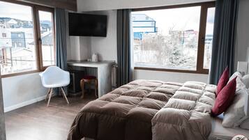 Ein modernes Hotelzimmer mit einem großen Bett, einem Schreibtisch und einem Fernseher.
