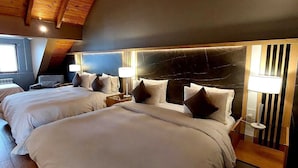 A hotel room with two beds, wooden ceiling beams, and a modern headboard. -  Hostería y Restaurante América (Ushuaia)