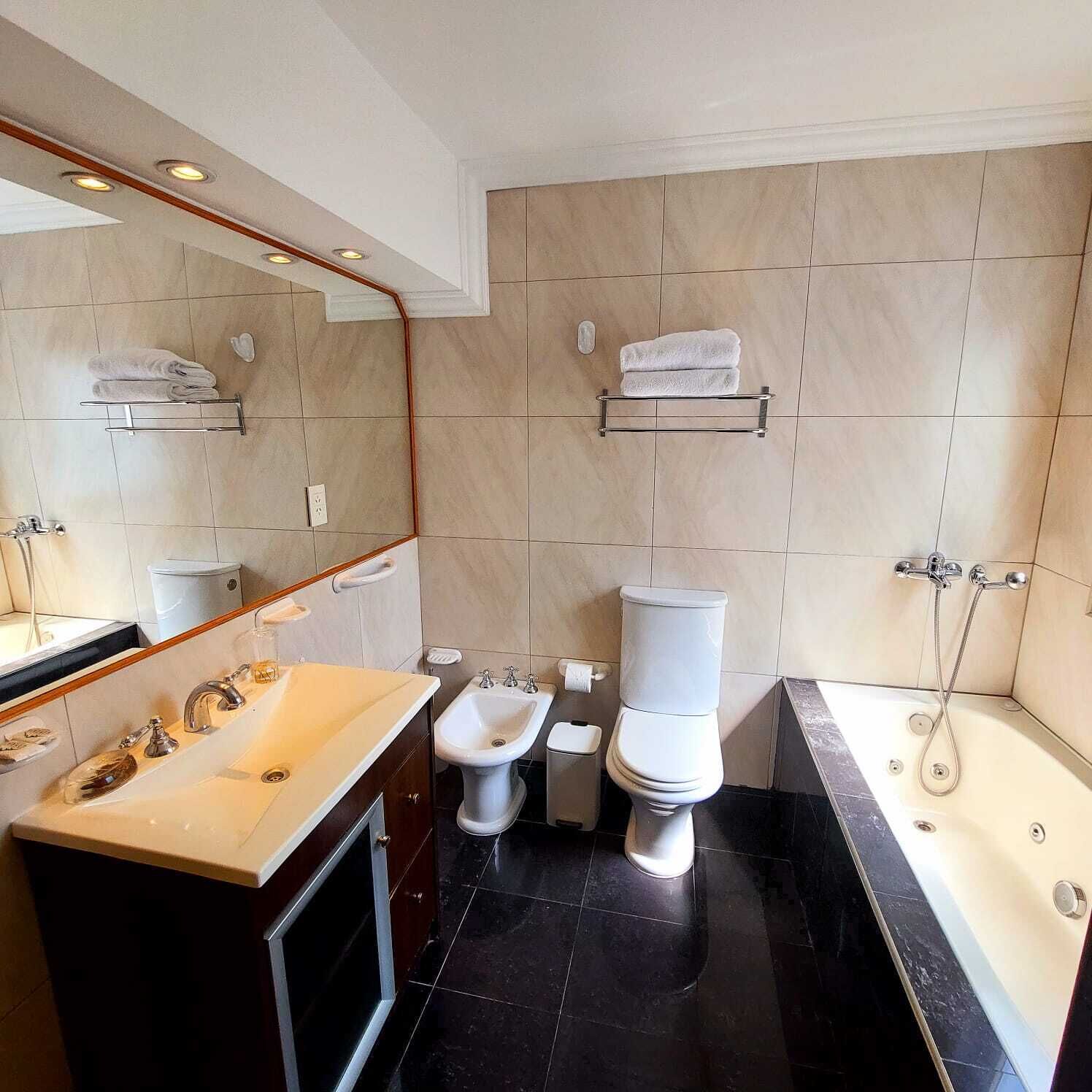 Un baño moderno con lavamanos, bidé, inodoro y bañera.