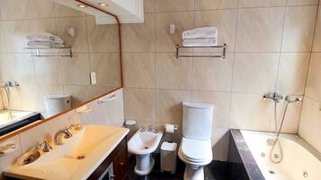 Un baño moderno con lavamanos, bidé, inodoro y bañera.