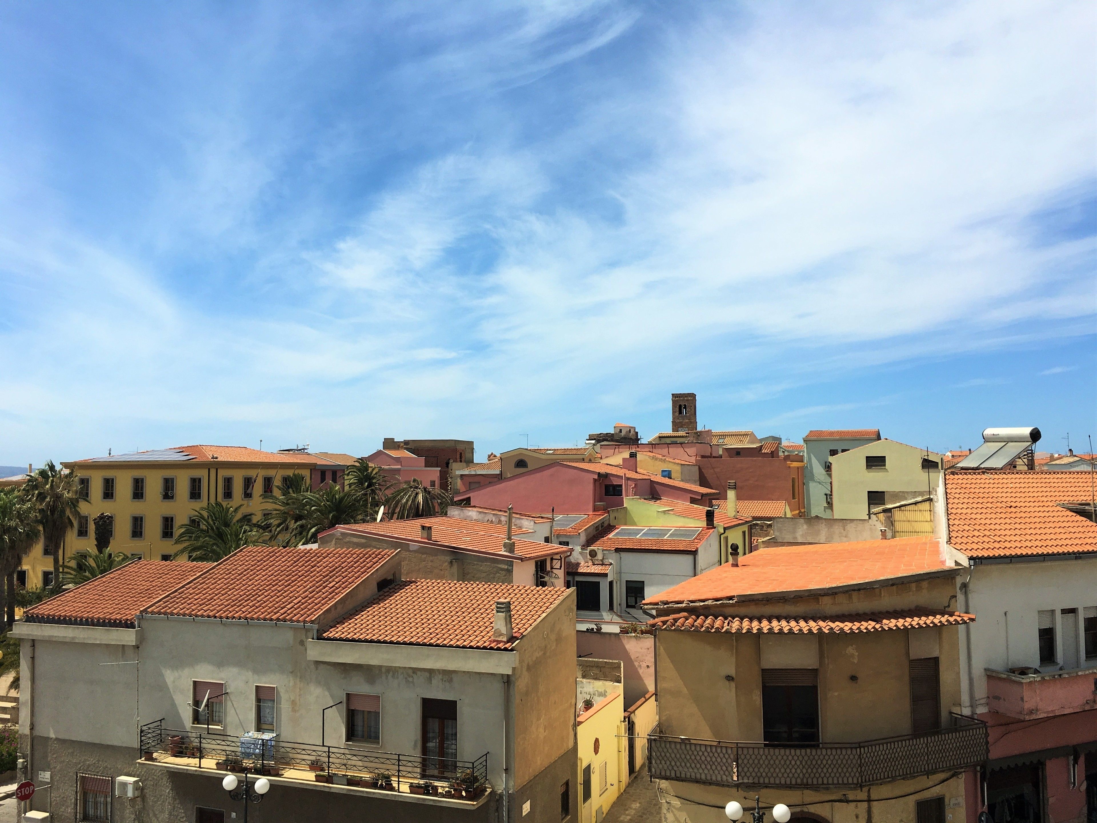 A view of a densely packed urban area with terracotta-tiled rooftops and a mix of building colors.