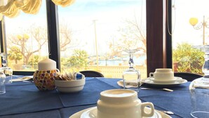 Mesa para dos con vista a un puerto deportivo y barcos.