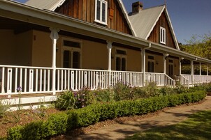 Una casa de madera tradicional con porche y barandillas blancas.