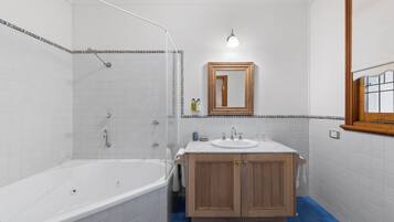 Un baño con bañera, lavamanos y ducha.