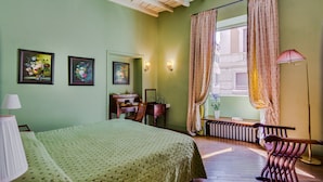 Une chambre à coucher avec un lit, un bureau, une chaise et un radiateur.