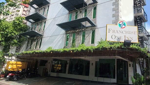 A building with a sign for "Franchise One Inn" on the ground floor. - Franchise One Hotel (Makati)