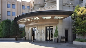 A hotel entrance with a curved canopy, large glass doors, and a sign reading "HOTEL TRUSTY". - Hotel Trusty Tokyo Bayside (Tokyo)