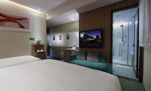 A hotel room with a bed, a seating area with a TV, a minibar, and a glass shower door. - Beauty Hotels - Beautique Hotel (Taipei)