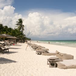 On the beach, white sand, sun loungers, beach towels