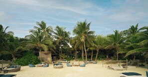 On the beach, white sand, sun loungers, beach towels