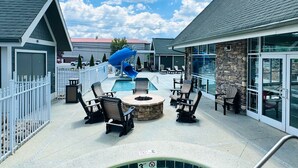 A pool area with lounge chairs, a hot tub, and a blue slide. - The Walden, Trademark Collection By Wyndham (Pigeon Forge)