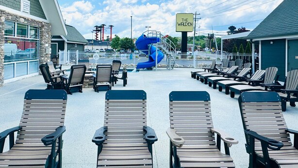 A pool area with lounge chairs, a blue water slide, and a sign reading "THE WALDEN". - The Walden, Trademark Collection By Wyndham (Pigeon Forge)