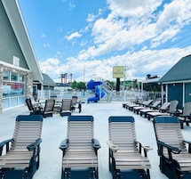 A pool area with lounge chairs, a blue water slide, and a sign reading "THE WALDEN".