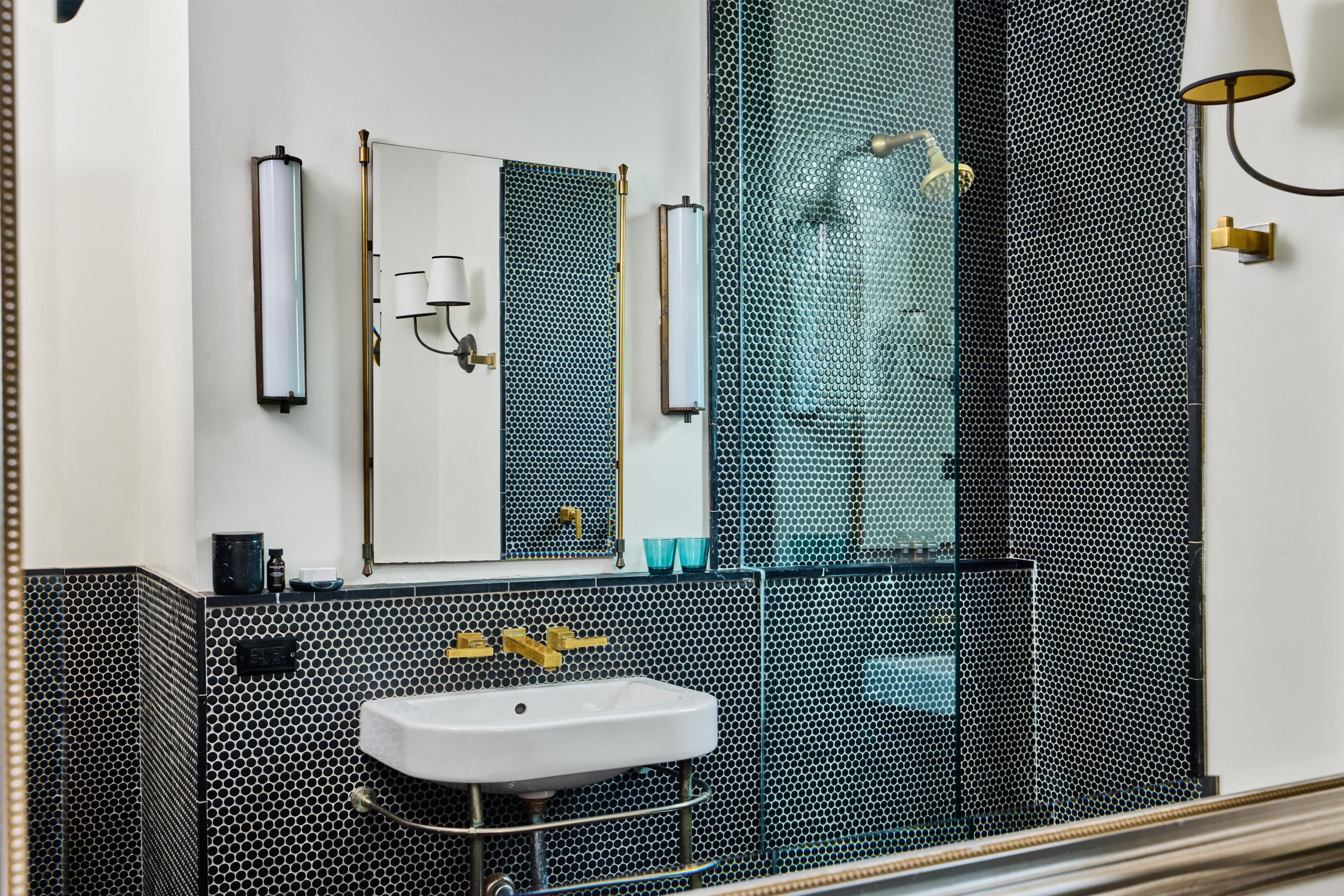 A bathroom with a white sink, a mirror, and a shower with a glass enclosure.