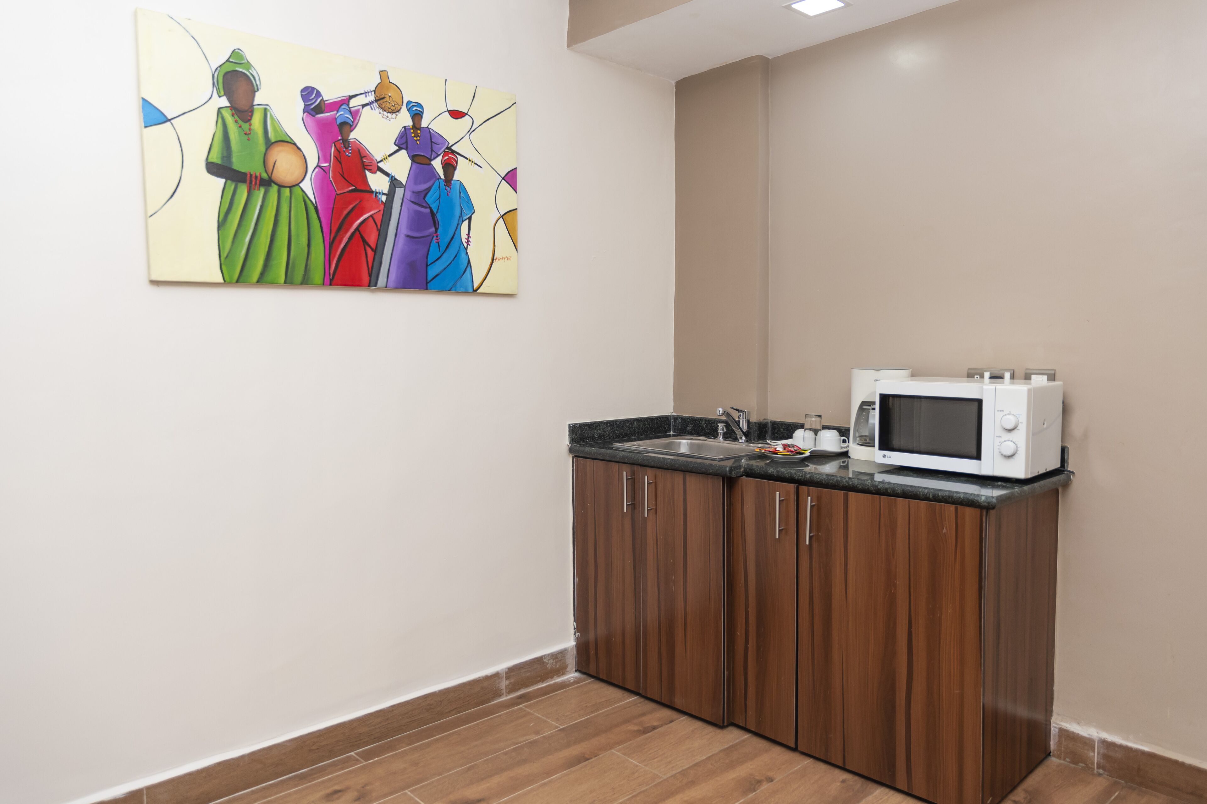 Una cocina con armarios de madera, un microondas y un lavamanos.