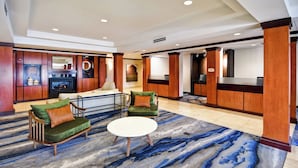 Eine geräumige Lobby mit einem teppichartigen Marmor-Muster, Holzmöbeln und einem Kamin.