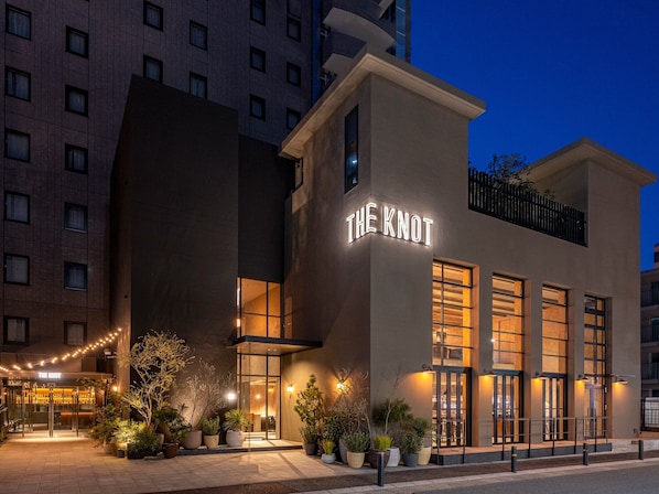 A hotel named 'The Knot' with a modern facade, large windows, and outdoor plants. - THE KNOT FUKUOKA Tenjin (Fukuoka)