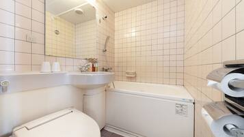 Kombination af bruser/badekar, hårtørrer, hjemmesko, bidet