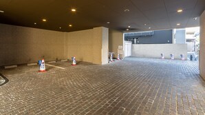 Un vaste espace intérieur aux murs en briques et au sol carrelé, agrémenté de plusieurs cônes de signalisation et d’une porte bien visible donnant accès à une autre partie.