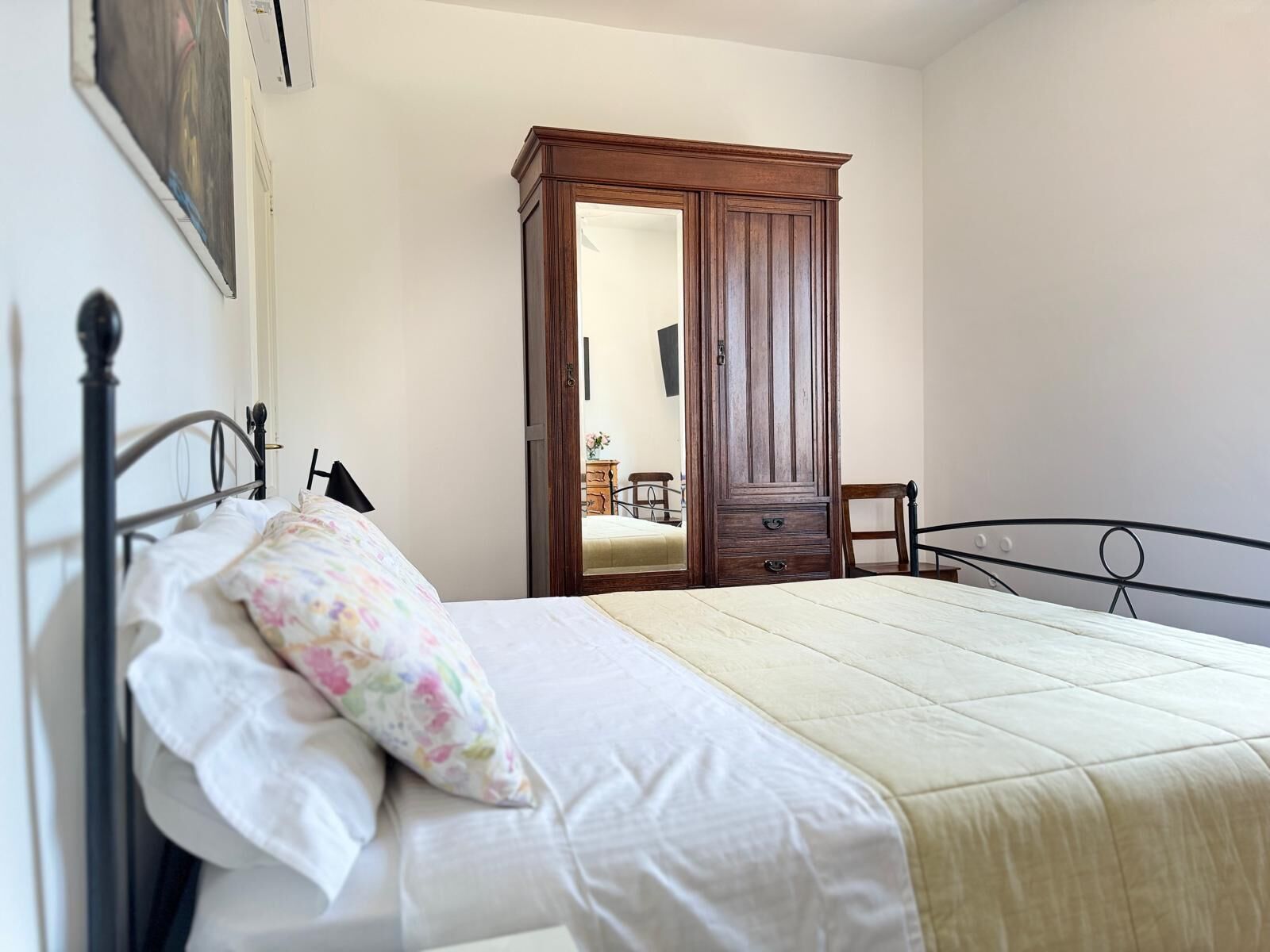 Une chambre à coucher avec un lit, une armoire en bois et un miroir.