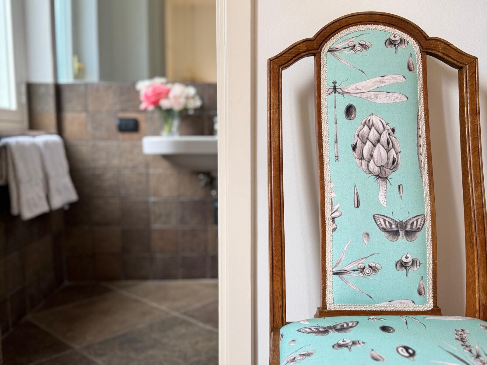 A bathroom with a tiled floor, a sink, and a mirror.