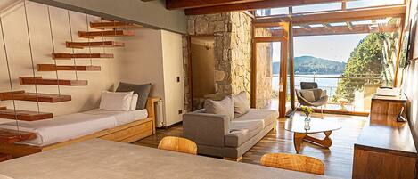 A modern interior with a stone wall, wooden furniture, and a view of the water.