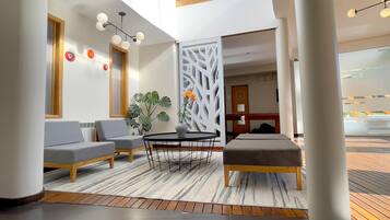 A modern lobby with a seating area, a decorative plant, and a white partition.