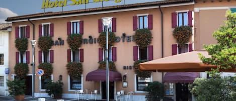 Hotel San Giorgio con terraza al aire libre y macetas con flores en las ventanas.