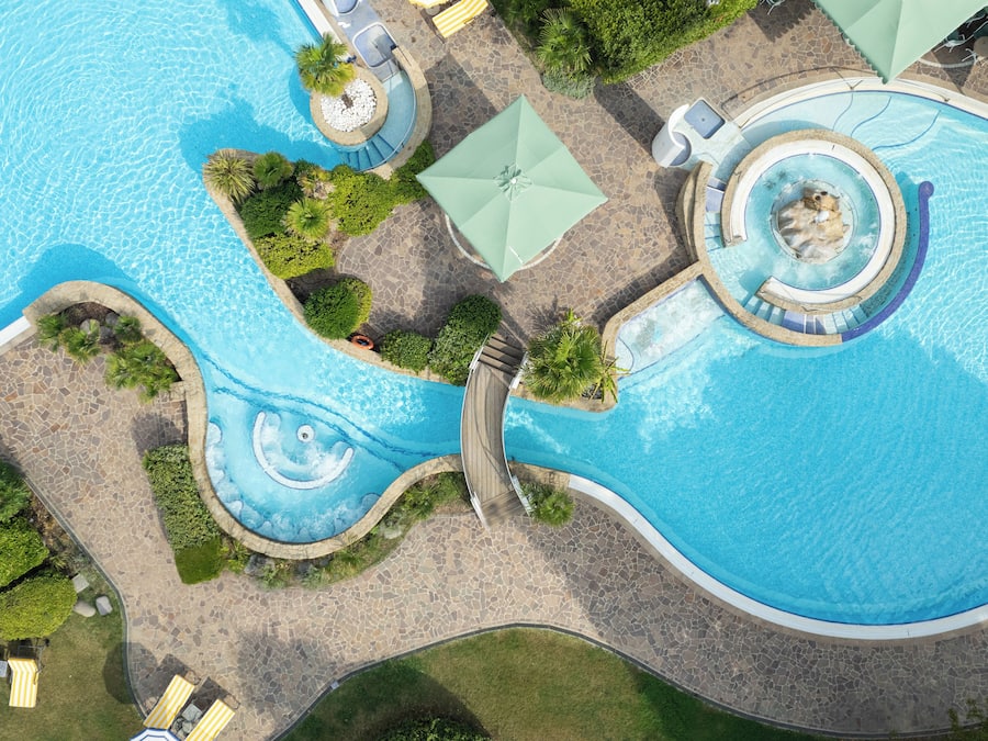 Una piscina techada, una piscina al aire libre, sombrillas