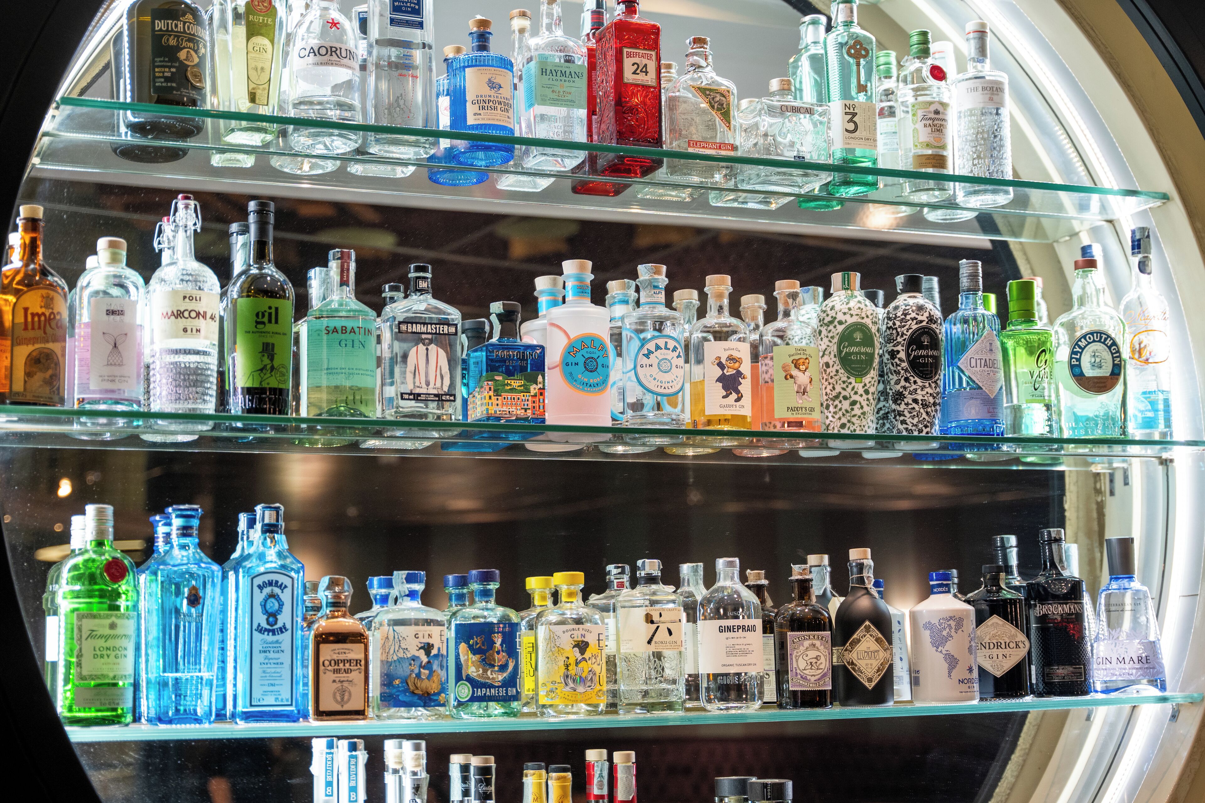 Une variété de bouteilles d’alcool sont exposées sur des étagères.