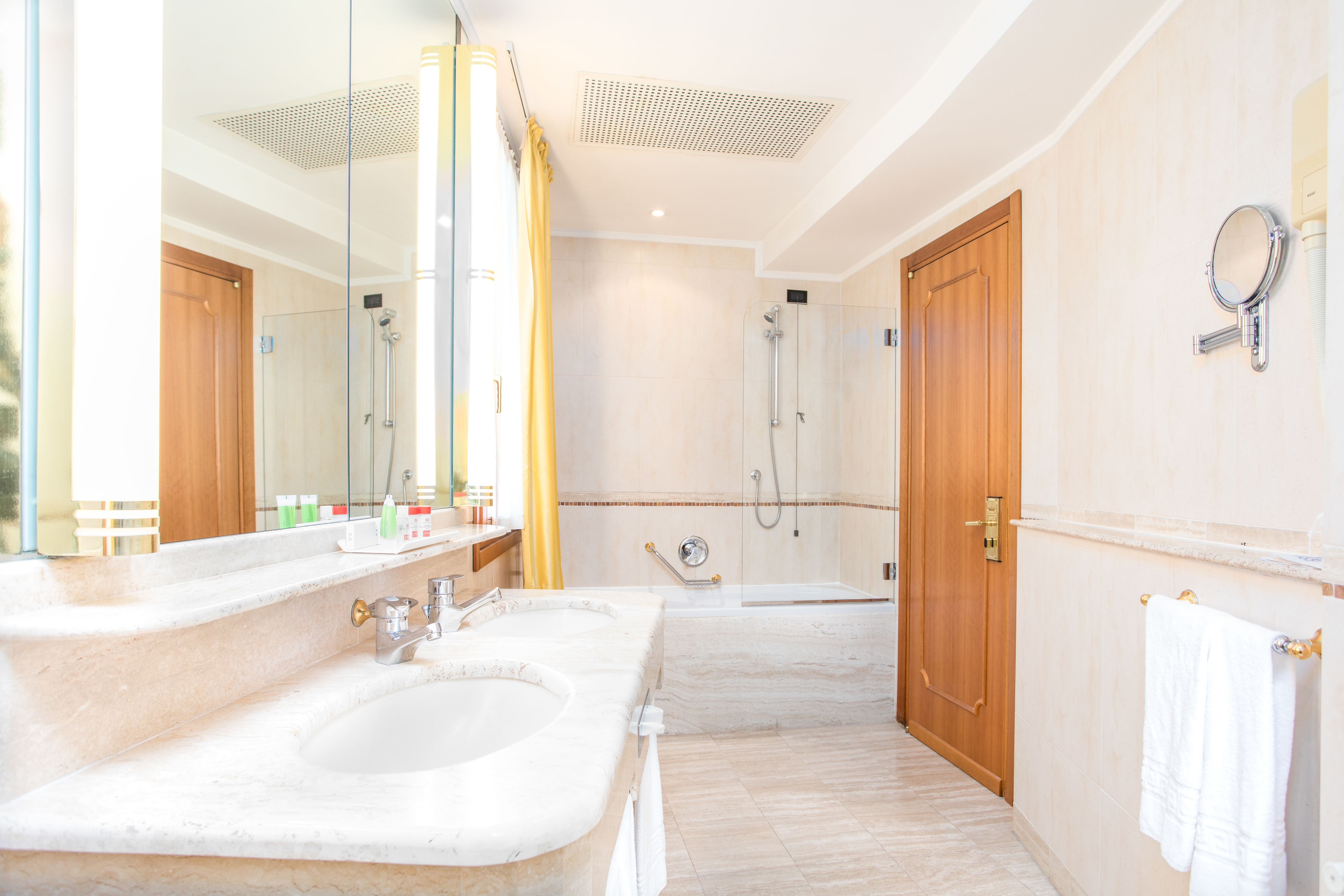 Ein Badezimmer mit zwei Waschbecken, einer Dusche und einem Spiegel.