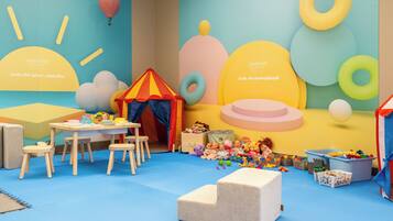 Children can play and explore in this lively room with a table, chairs, tent, and plenty of toys.
