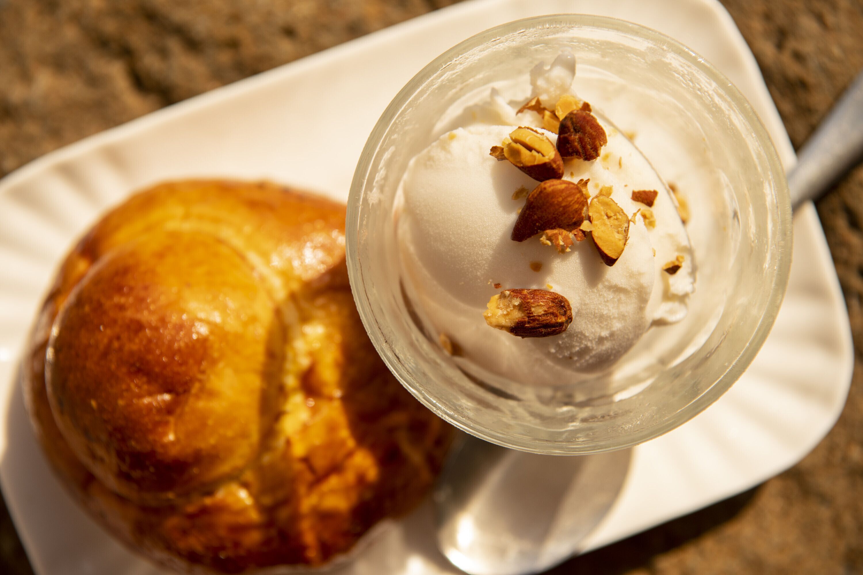 Uma sobremesa com massa folhada e um copo de chantilly com nozes.