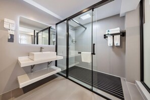 A modern bathroom with a glass shower enclosure, a white sink, and a towel rack. - Old Town of Lijiang Tianxiangge Hotel (Old Town of Lijiang South Store) (Lijiang)