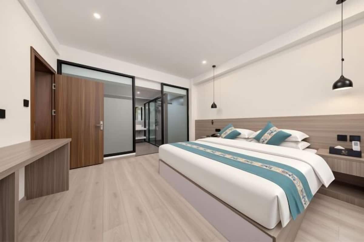 A bedroom with a bed, bedside table, and a desk.