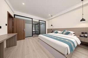 A bedroom with a bed, bedside table, and a desk. - Old Town of Lijiang Tianxiangge Hotel (Old Town of Lijiang South Store) (Lijiang)