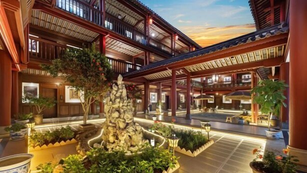 Un patio tradicional con jardín de rocas, plantas en macetas y una estructura de madera.