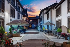A courtyard with outdoor seating, a central walkway, and traditional architecture. - Old Town of Lijiang Tianxiangge Hotel (Old Town of Lijiang South Store) (Lijiang)