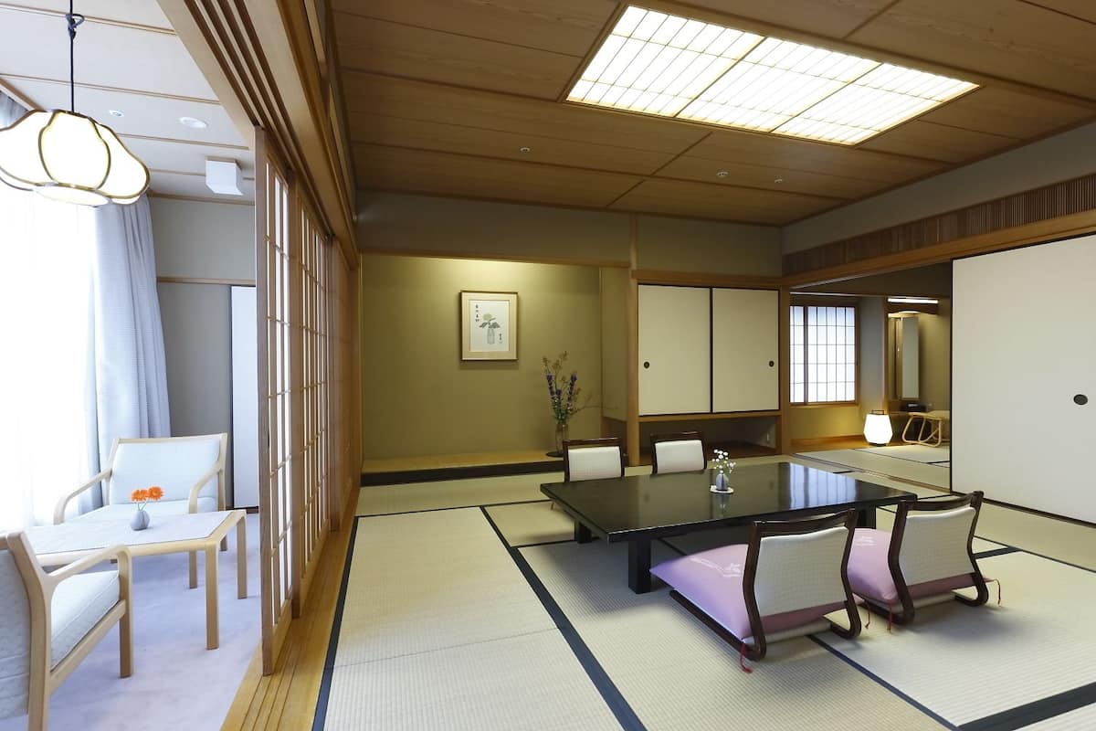 A traditional Japanese-style room with tatami flooring, a low table, and sliding doors.